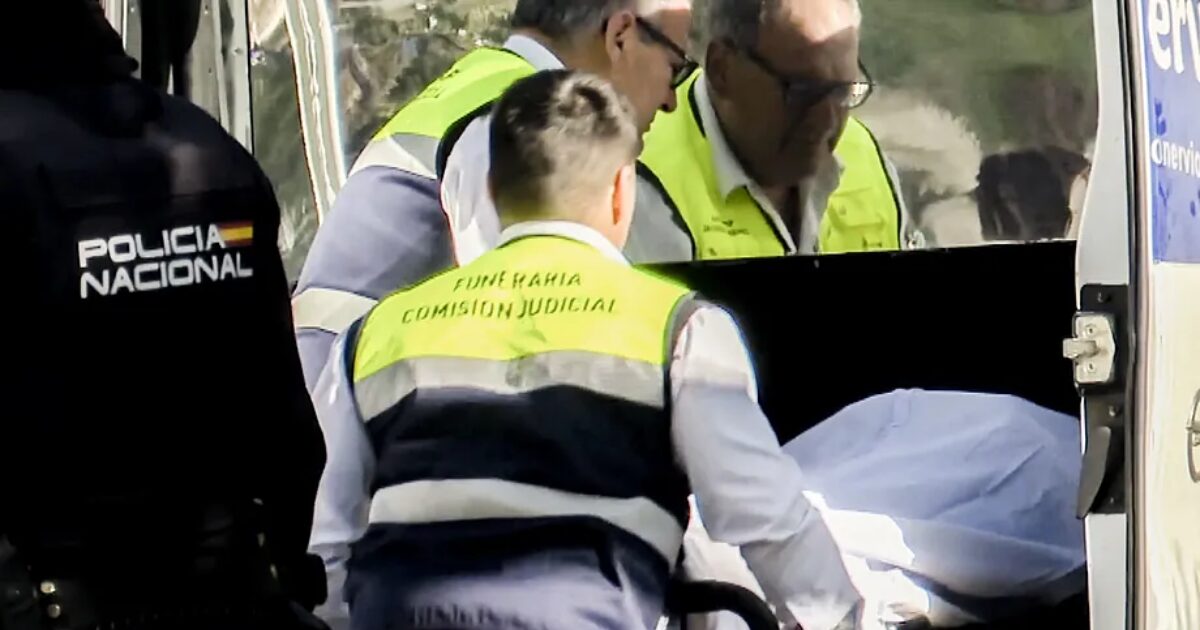 Miembros de la funeraria y de la Policía Nacional trasladan el cadáver del joven de 21 años