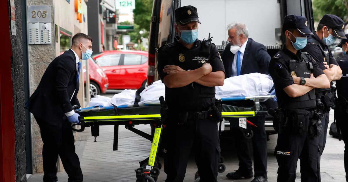 Miembros del servicio funerario trasladan un cadáver de la vivienda sita en el número 205 de la calle Serrano de Madrid, donde un hombre ha matado a su pareja y a otra mujer y después se ha suicidado.