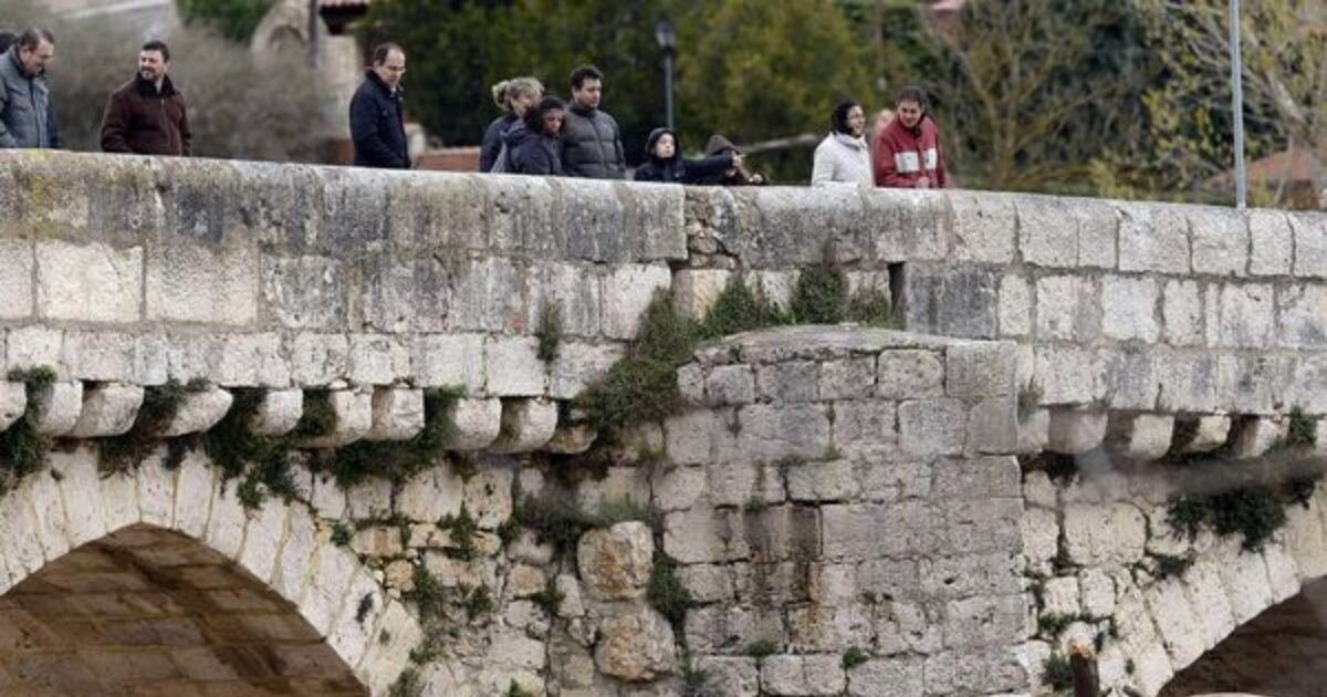 Un grupo de personas observa el caudal del río Pisuerga. (EFE/Nacho Gallego)